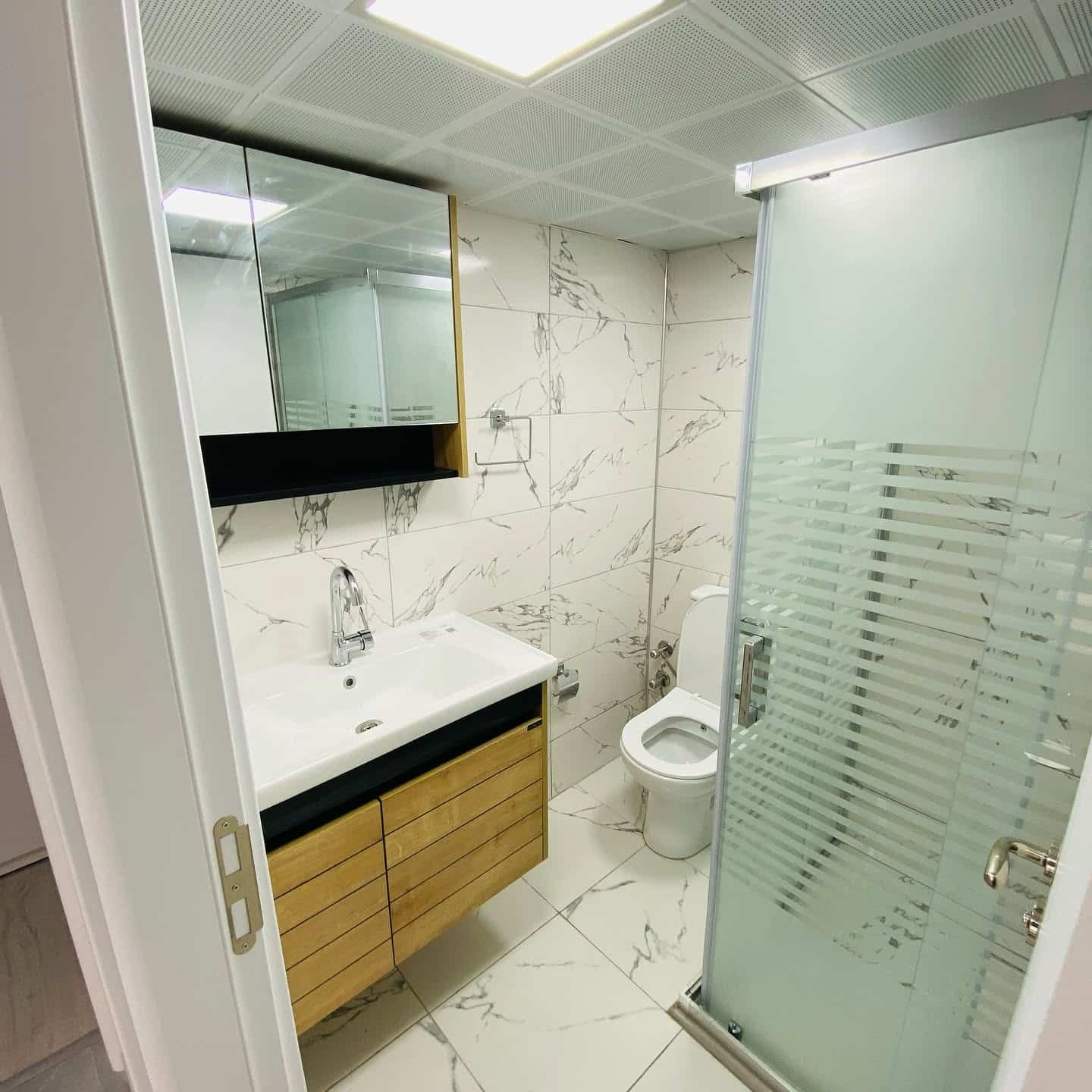 Cam duş kabini ve ahşap lavabo dolabı
