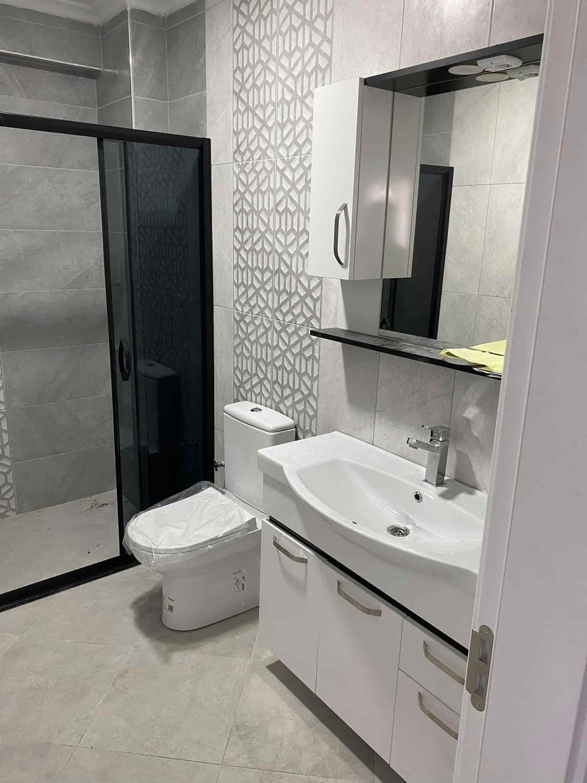 Banyo lavabo ünitesi ve siyah duş kabini